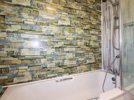 A bathroom with a bathtub and shower in Merlin's Retreat Tintagel