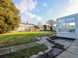 A garden with grass and stone pathway at Merlin's Retreat in Tintagel