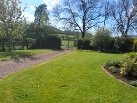 A garden with a pathway and gate at Lawn Lodge in Ashleworth