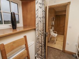 A bathroom view with a chair and towel rack at Long Cart Cottage in Embleton