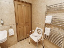A bathroom with a hand basin and towel rack at Long Cart Cottage in Embleton
