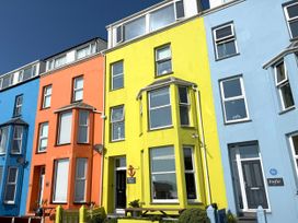 A row of colorful buildings with windows and doors at The View in Criccieth