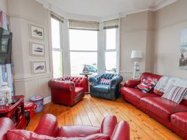 A living room with red leather furniture at The View in Criccieth