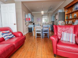A kitchen with red sofas and a dining table at The View in Criccieth