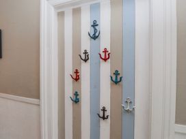 A hallway with anchor hooks on a striped door at The View in Criccieth