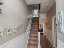 A hallway with a staircase and decorative banner at The View in Criccieth