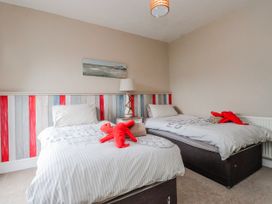 A bedroom with two beds and a lamp at The View in Criccieth