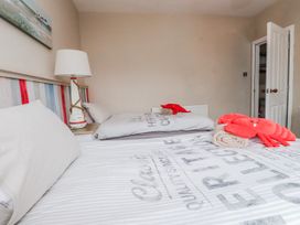 A bedroom with two beds and a lamp at The View in Criccieth