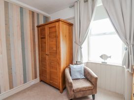A bedroom with a wardrobe and armchair at The View in Criccieth