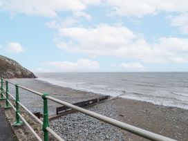 A beach with pebbles and sea under a cloudy sky at The View in Criccieth