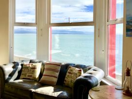 A living room with a sofa and pillows overlooking the sea at The View in Criccieth