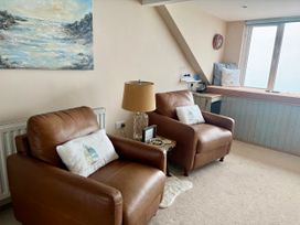 A living room with two leather chairs and a window at The View in Criccieth