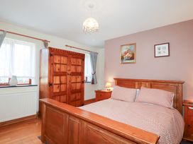 A bedroom with a bed and wardrobe at Kingfisher Barn East Taphouse