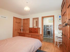 A bedroom with a bed and dresser at Kingfisher Barn in East Taphouse