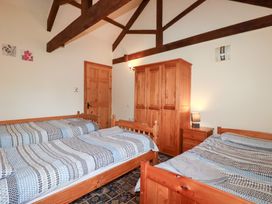 A bedroom with beds and a wardrobe at Kingfisher Barn East Taphouse