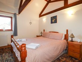 A bedroom with a bed and nightstands at Kingfisher Barn in East Taphouse