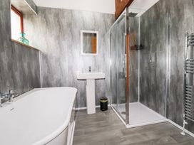 A bathroom featuring a bathtub, sink, shower, and towel radiator at Kingfisher Barn in East Taphouse