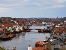 A view of a harbor with houses and a bridge at Kingfisher in Whitby