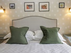 A bedroom with a bed and framed pictures at Gable End in Coniston near Hawkshead