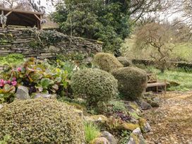 A garden with bushes and a bench at Gable End in Coniston near Hawkshead