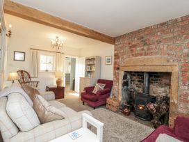A living room with a fireplace and sofas at Croft View in Fylingthorpe near Robin Hood's Bay