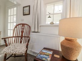 A sitting room with a rocking chair and a lamp at Croft View Fylingthorpe near Robin Hood's Bay