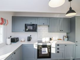 A kitchen with cabinets, microwave, kettle, and toaster at Croft View Fylingthorpe near Robin Hood's Bay