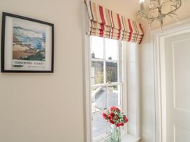 A hallway with a flower vase and a framed picture at Croft View in Fylingthorpe near Robin Hood's Bay