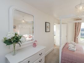 A bedroom with a mirror and a four-poster bed at Croft View in Fylingthorpe near Robin Hood's Bay
