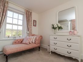 A bedroom with a chaise lounge and a dresser at Croft View in Fylingthorpe near Robin Hood's Bay