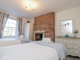 A bedroom with two beds and a fireplace at Croft View in Fylingthorpe near Robin Hood's Bay