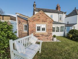 A garden with a bench and a brick cottage at Croft View in Fylingthorpe near Robin Hood's Bay