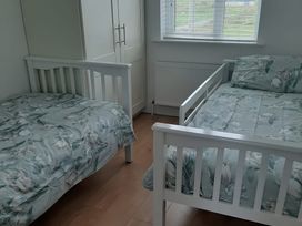 A bedroom with two beds and a wardrobe at 63 Moinin, Kilkee, County Clare