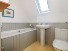 A bathroom with a bathtub sink toilet and skylight window at St Tudwals View in Abersoch