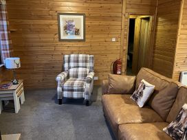 A living room with an armchair and a sofa at Wildcat Lodge in Newtonmore