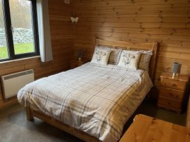 A bedroom with a bed and bedside tables at Wildcat Lodge in Newtonmore