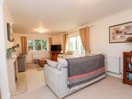 A living room with a sofa, coffee table, and television at Fernlea in Morfa Nefyn