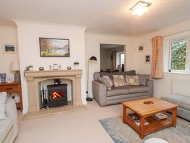 A living room with a fireplace and sofa at Fernlea in Morfa Nefyn
