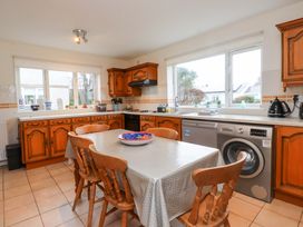 A kitchen with a table and chairs at Fernlea in Morfa Nefyn