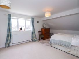 A bedroom with a bed and window at Fernlea in Morfa Nefyn