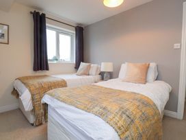 A bedroom with two single beds and a lamp at Fernlea in Morfa Nefyn