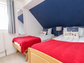 A bedroom with two beds and a mirror at Fernlea in Morfa Nefyn