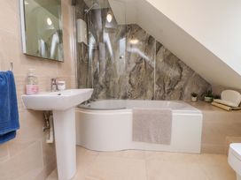 A bathroom with a bathtub and sink at Fernlea Morfa Nefyn
