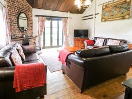 A living room with leather sofas and a wooden coffee table at The Dairy in Carrog near Corwen