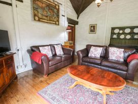 A living room with two brown leather sofas and a wooden coffee table at The Dairy in Carrog near Corwen