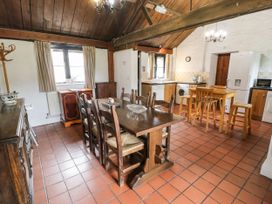 A kitchen and dining area with wooden table and chairs a kitchen island and appliances at The Dairy in Carrog near Corwen