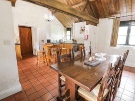 A kitchen and dining area with wooden table and chairs wooden ceiling and white walls at The Dairy in Carrog near Corwen