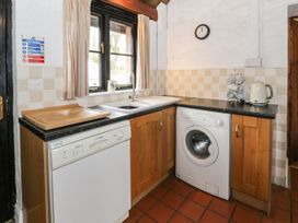A kitchen with a dishwasher washing machine sink and kettle at The Dairy in Carrog near Corwen