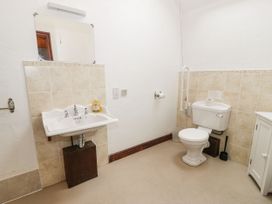 A bathroom with a sink a mirror a toilet and a cabinet at The Dairy in Carrog near Corwen