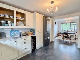 A kitchen with cabinets and a dining area at Kilcarreg in Rock near Wadebridge